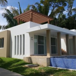 Casa Bartholow – single-story white stucco home with front porch and lawn