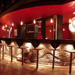Mantra Club – lounge with rows of upholstered chairs and red ambient light