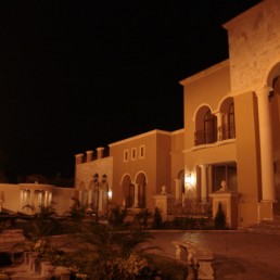 Modern home exterior at dusk with warm interior lights (Residencia La Paz)
