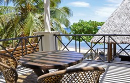Wooden pier with palapa over turquoise water at sunset