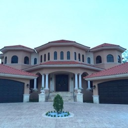 Casa Urbistondo – two-story coastal home with wraparound balcony and red roof by Hugo Coello