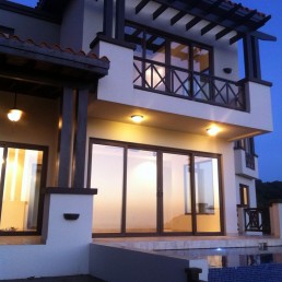 Casa Zambito – modern exterior with warm night lighting and large windows by Hugo Coello